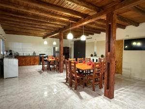 a kitchen and dining room with wooden tables and chairs at Refugio del Alma in Villa Anizacate