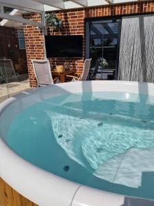 a jacuzzi tub in a patio with a table and chairs at Ferienhaus Sweet-Escape in Löningen
