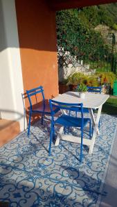 a white table and two blue chairs on a patio at la terrazza relax in Corniglia