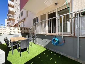 a patio with a table and chairs on a balcony at Apto Primera Línea con Piscina - Guipas Beach in Puerto de Mazarrón
