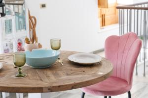 a wooden table with a bowl and two glasses on it at Ire' Luxury Suite in Avola