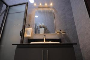 a bathroom with a sink and a mirror at Taye Apartments in Entebbe +17 photos