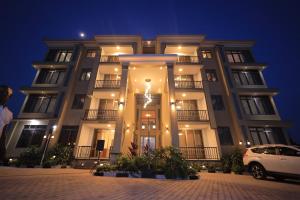 a building with a car parked in front of it at Taye Apartments in Entebbe