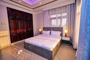 a bedroom with a large bed and a window at Taye Apartments in Entebbe