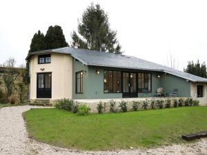 a green and white house with a yard at La Maison Aux Fleurs by La Boîte En Plus in Courteuil