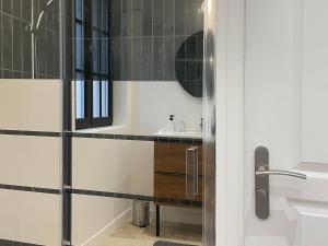 a bathroom with a sink and a mirror at La Maison Aux Fleurs by La Boîte En Plus in Courteuil +70 photos