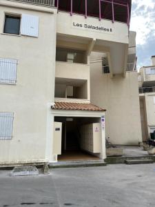 a building with a garage with a parking lot at Appartement les saladelles in Le Grau-du-Roi