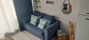 a blue couch with two pillows in a room at Appartement les saladelles in Le Grau-du-Roi