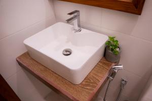 a white sink sitting on a wooden shelf in a bathroom at Nest & Rest in Sri Jayewardenepura Kotte