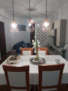 a dining room table with chairs and lights at Madeira Home Holidays in Caniço
