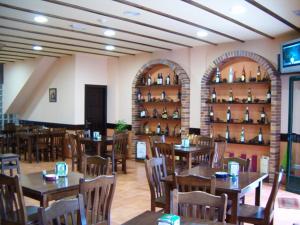 a restaurant with tables and chairs and shelves with wine bottles at Hotel O Lagar in Cambados