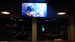 a flat screen tv on a wall with a guitar at Hotel Canta Galo Tower in Jacarèzinho