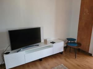 a white entertainment center with a flat screen tv on it at Apartamenti HUGO in Valmiera