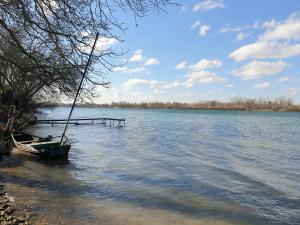 a boat sitting in the water next to a dock at Gîte L'échappée Bleue in Saint-Germain-du-Plain
