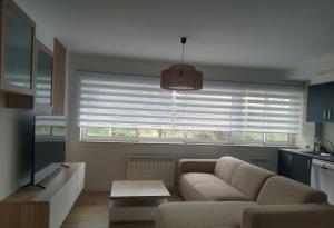 a living room with a couch and a large window at Apartamento "Playa de Sada" in Sada