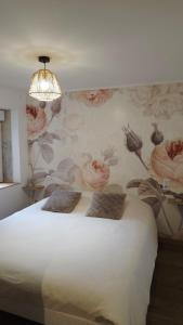a bedroom with a bed with a floral wall at Gîte L'échappée Bleue in Saint-Germain-du-Plain