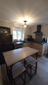 a kitchen with a wooden table and a stove at Gîte L'échappée Bleue in Saint-Germain-du-Plain