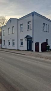 a white building on the side of a street at Apartamenti HUGO in Valmiera