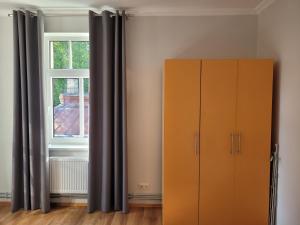 a bedroom with a cabinet and a window at Apartamenti HUGO in Valmiera