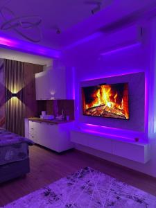 a living room with a fireplace with purple lighting at Studio Apartman Kostić in Gracanica