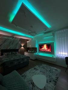 a bedroom with a fireplace and a bed and a couch at Studio Apartman Kostić in Gracanica +3 photos