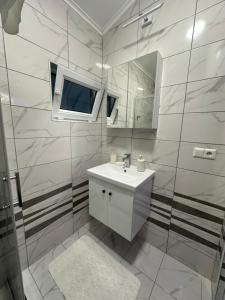 a bathroom with a sink and a mirror at Studio Apartman Kostić in Gracanica