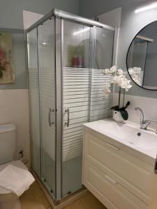 a bathroom with a glass shower and a sink at נופש בפינה in Rosh Pinna +34 photos