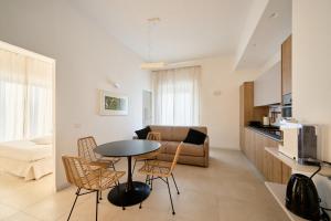 a living room with a table and chairs and a couch at Pilone del Monaco - Pool & Free Parking in Vieste