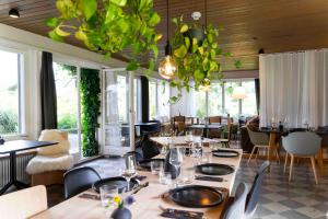 a dining room with tables and chairs and windows at Lenk Lodge - Boutique & Design Hotel und Apartements in Lenk