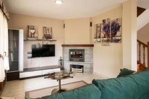 a living room with a couch and a fireplace at Villa Senda Llanes – Jardín, Terraza y Playa Cerca in Llanes