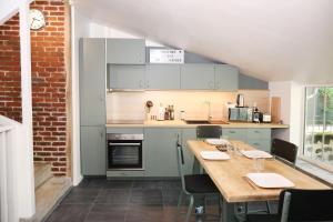 a kitchen with a wooden table with chairs in it at Suite Garden by La Boîte En Plus in Senlis