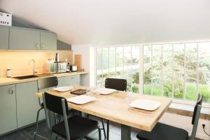 a kitchen with a table with chairs and a large window at Suite Garden by La Boîte En Plus in Senlis