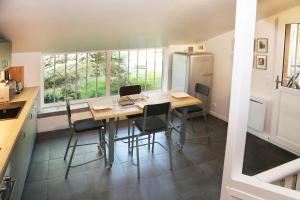 a kitchen with a wooden table and chairs and a window at Suite Garden by La Boîte En Plus in Senlis +34 photos