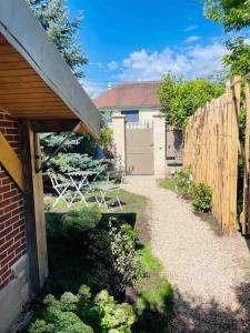 a backyard with a wooden fence and a garden at Suite Garden by La Boîte En Plus in Senlis
