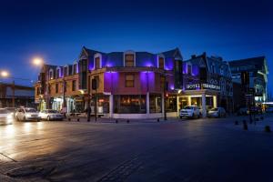 a city street at night with a building with purple lights at Hotel Tierra Del Fuego in Punta Arenas
