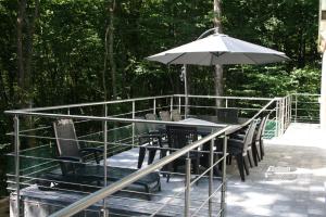 a table and chairs with an umbrella on a patio at Chalet Jarte in Barvaux