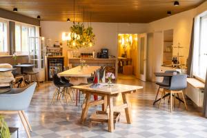 a dining room with tables and chairs and a kitchen at Lenk Lodge - Boutique & Design Hotel und Apartements in Lenk +42 photos