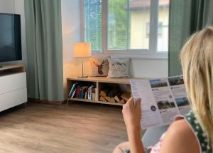a young girl reading a magazine in a living room at Ferienwohnung Zirbenglück in Siegsdorf