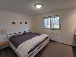 a bedroom with a large bed and a window at Chalet Jarte in Barvaux