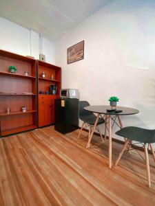 a room with a table and chairs and a refrigerator at Cossy studio apartment in downtown in Cuenca