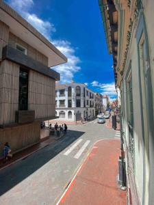 a city street with buildings and people walking on the street at Cossy studio apartment in downtown in Cuenca +2 photos