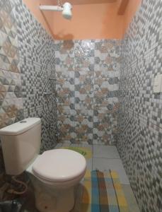 a bathroom with a toilet and a tiled wall at Chalet del lago Don Asterio in Ciudad del Este +32 photos