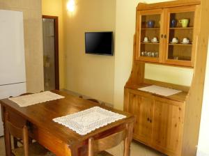 a dining room with a wooden table and a cabinet at Agriturismo Tenuta La Siesta in Gallipoli