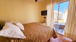 a bedroom with a bed and a balcony with a table at Cabañas Pinamar in La Serena