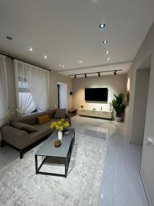 a living room with a couch and a table at White Apartment in Baku
