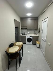 a small kitchen with a table and a table and chairs at White Apartment in Baku