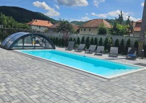 a swimming pool with an arch and chairs in a yard at Gerab Resort in Praid