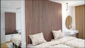 a hotel room with two beds and a mirror at Beachfront 2BR Apartment with Balcony and Sea View, Biser Mora in Rafailovici