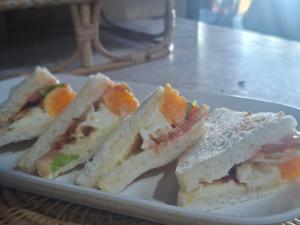 three sandwiches on a white plate on a table at Koh Phaluay Eco Resort in Ko Phaluai