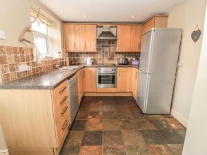 a kitchen with wooden cabinets and a stainless steel refrigerator at Shepherds Nook in Chathill